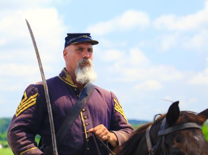 A Union Master Sergeant on horseback with a saber rides forth reenacting the battle of Gettysburg<br>
[photo credit: Steve Hogan]